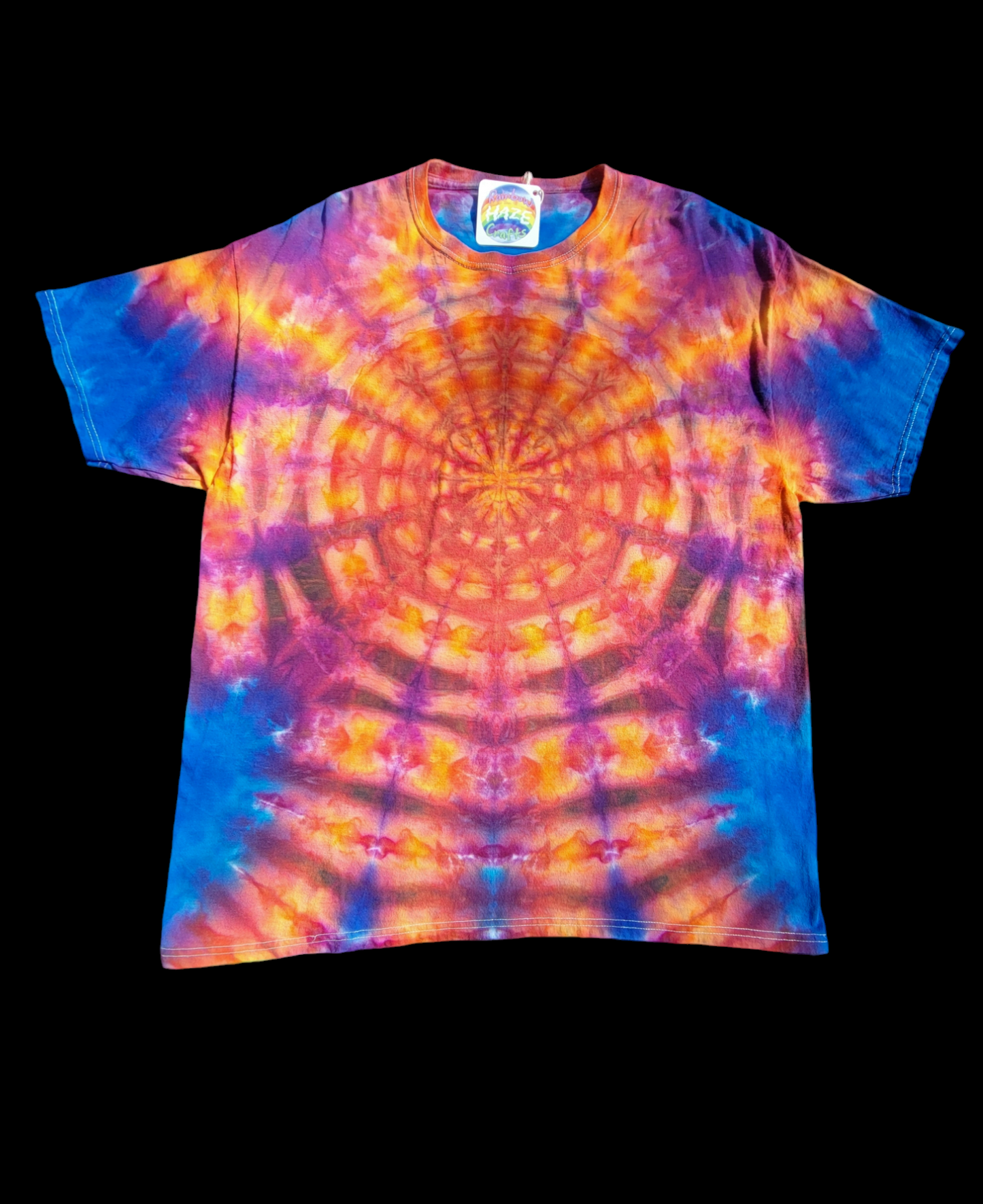 Front view of XL tie-dye t-shirt in bright oranges, blues, and pinks. Mandala pattern bursts out from the center of the shirt.